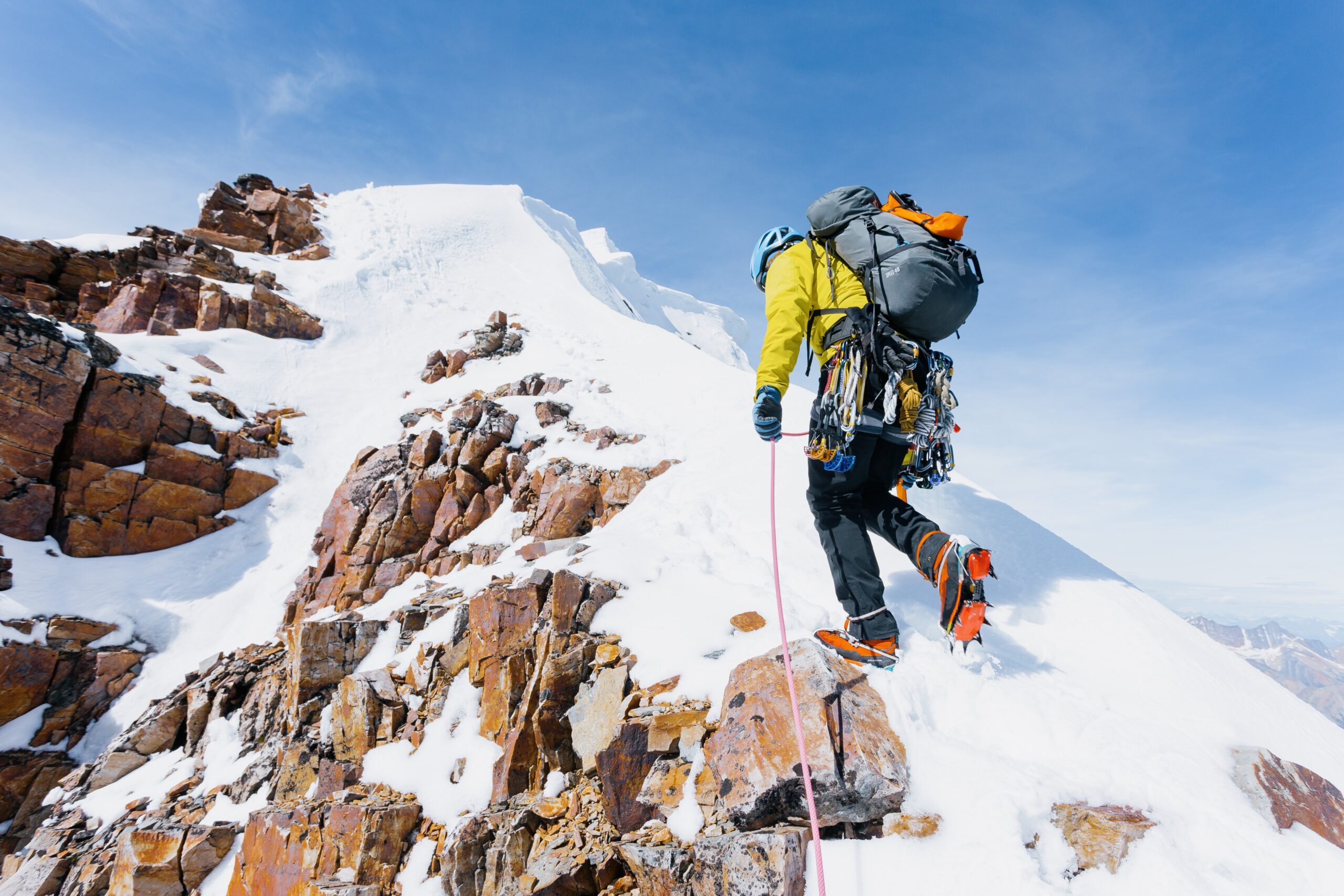A mountaineer reaching the top of a snowy mountain