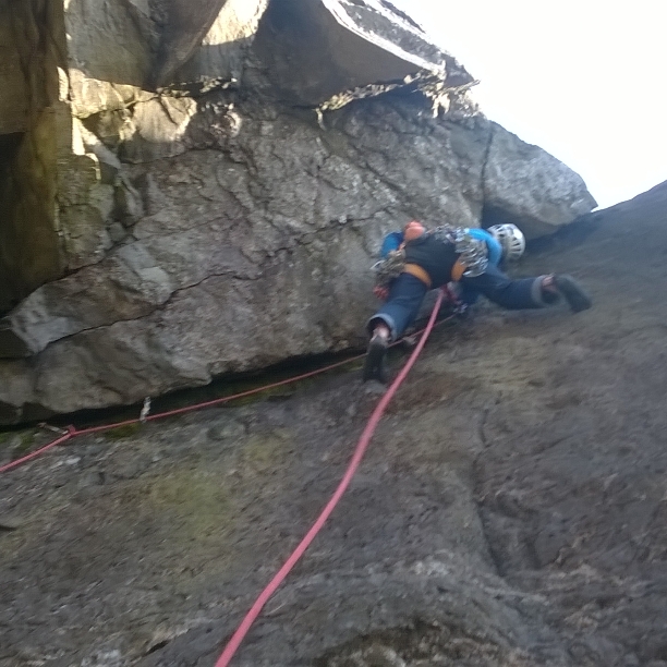 A climber scaling a difficult overhang
