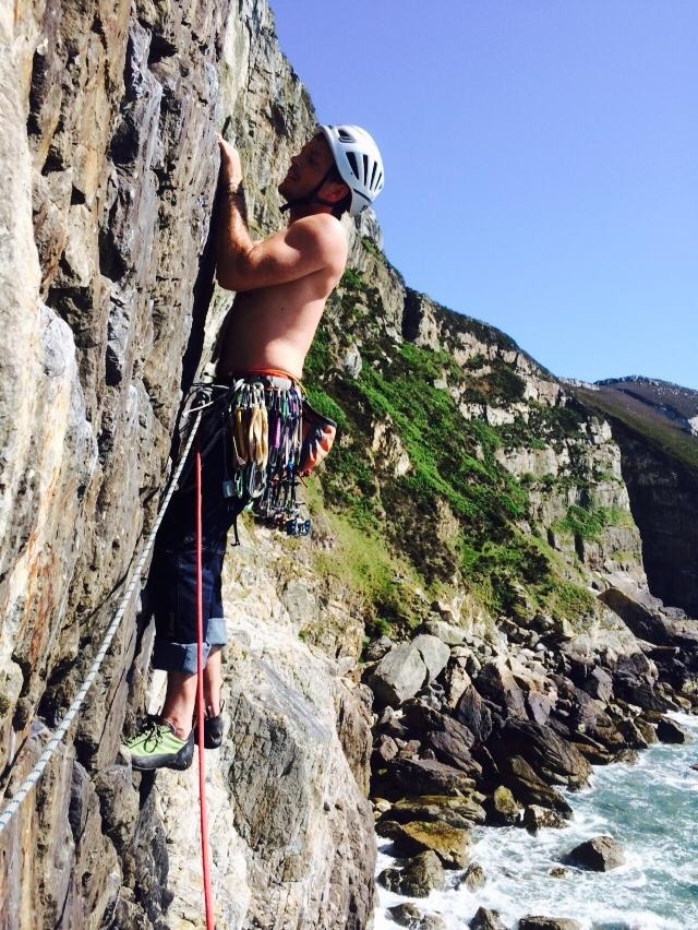Tim leading a climb up a sea cliff