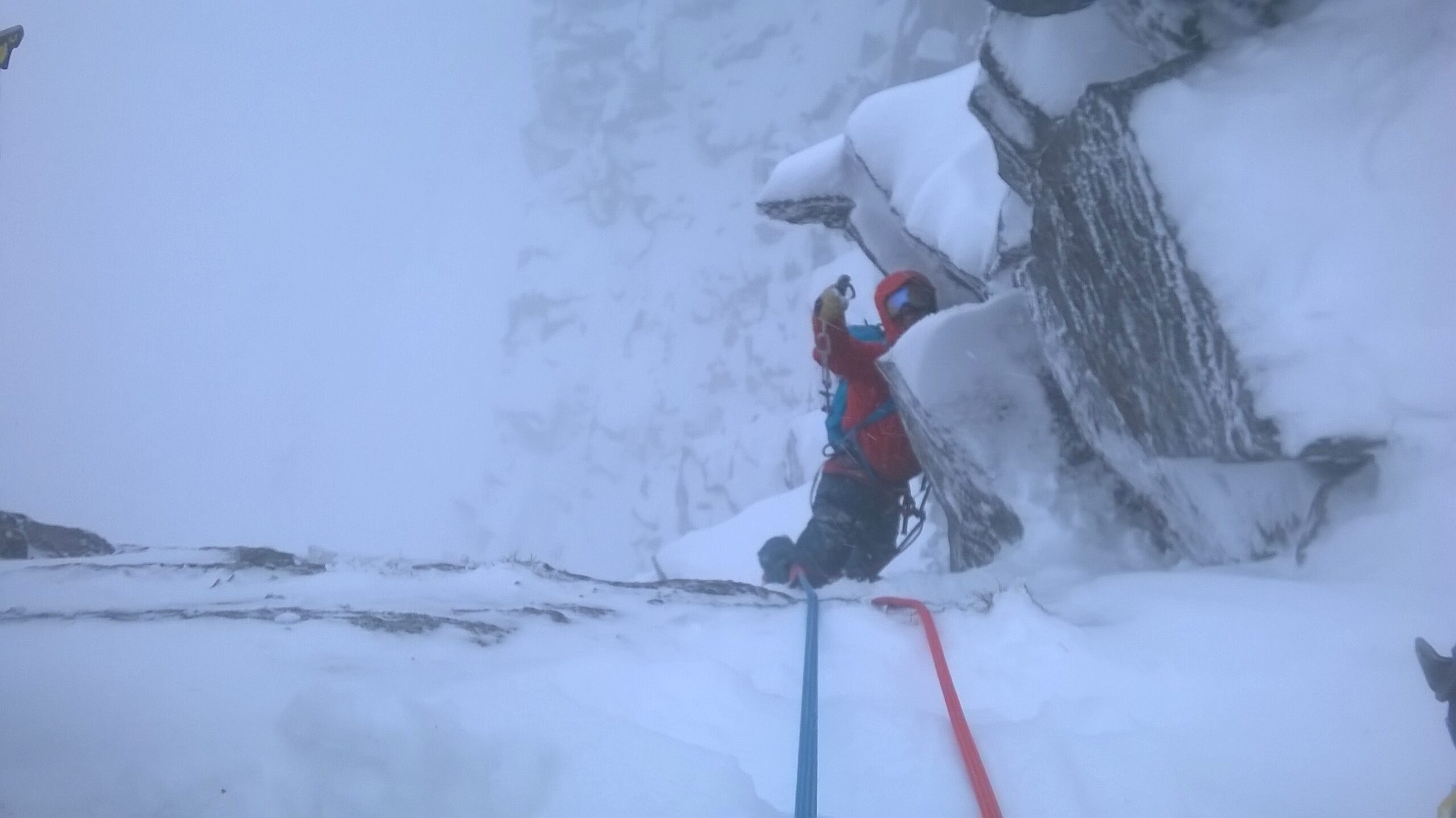 Tim climbing up a mountain in a blizzard