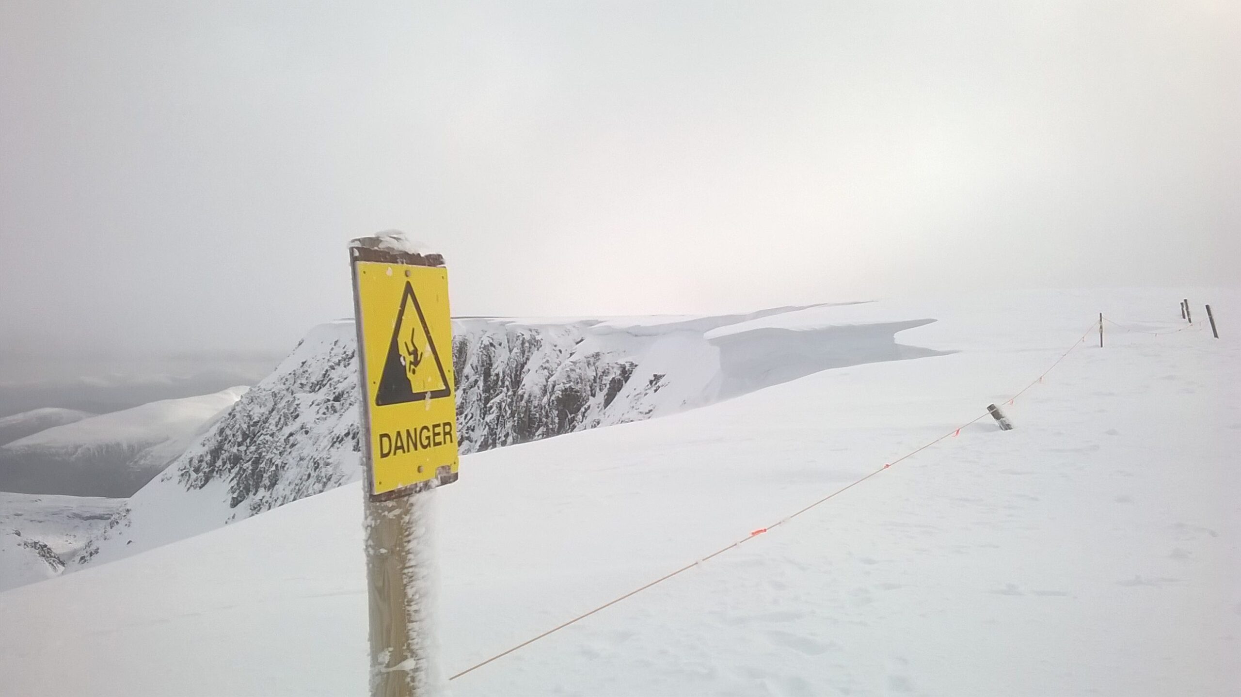 A danger sign on a snowy cliff
